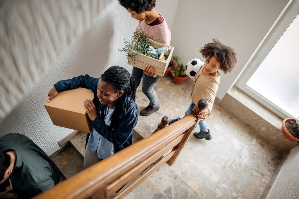Family arriving at their new home walking through the stairs.
